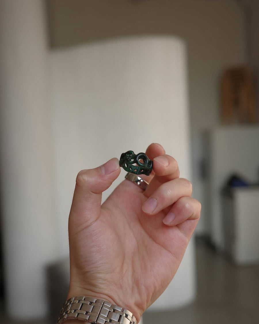 Hand holding a green wax ring carved at a beginner wax carving class in Toronto