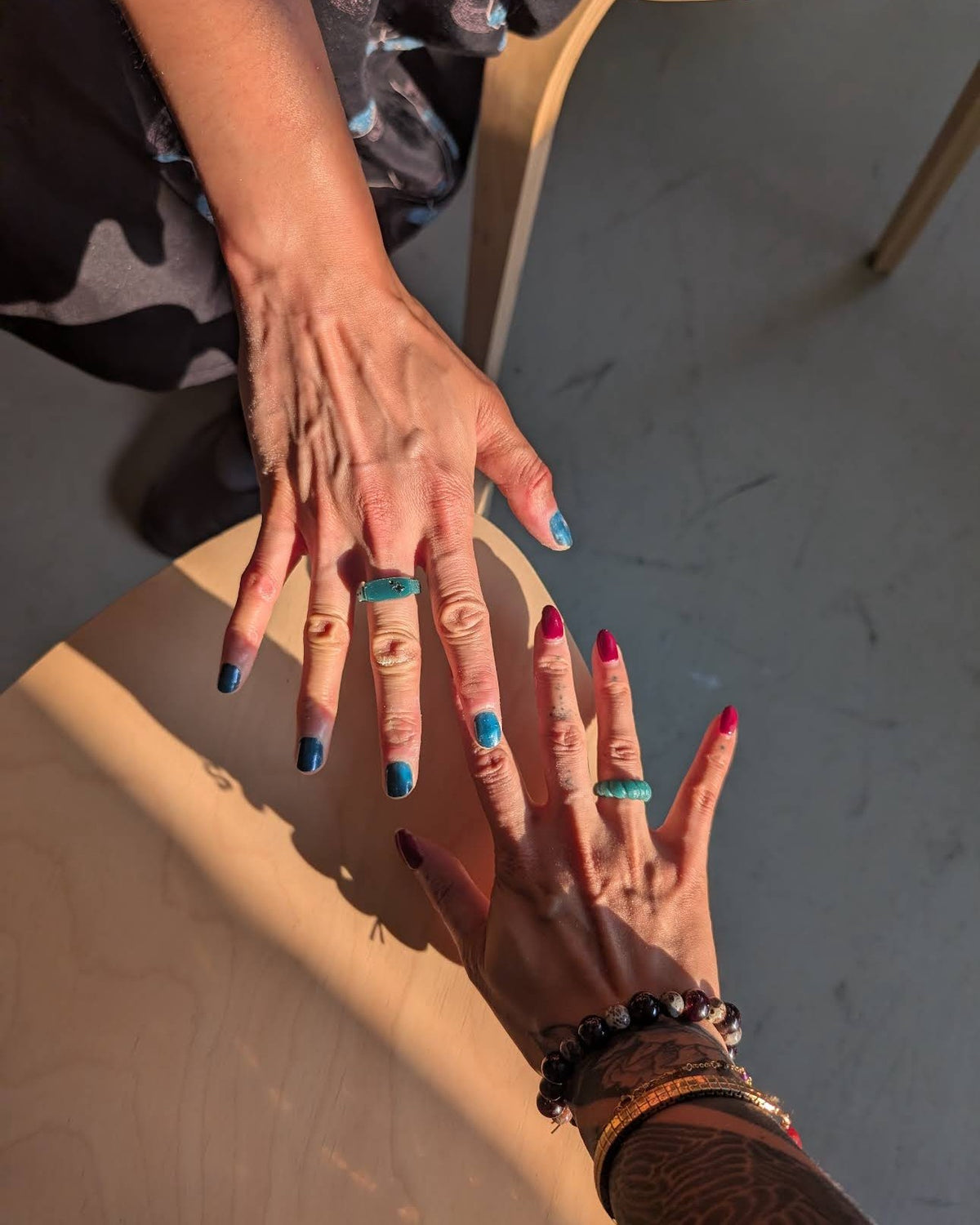Two sisters showing the rings they carved at a Nūrain wax carving workshop in Toronto